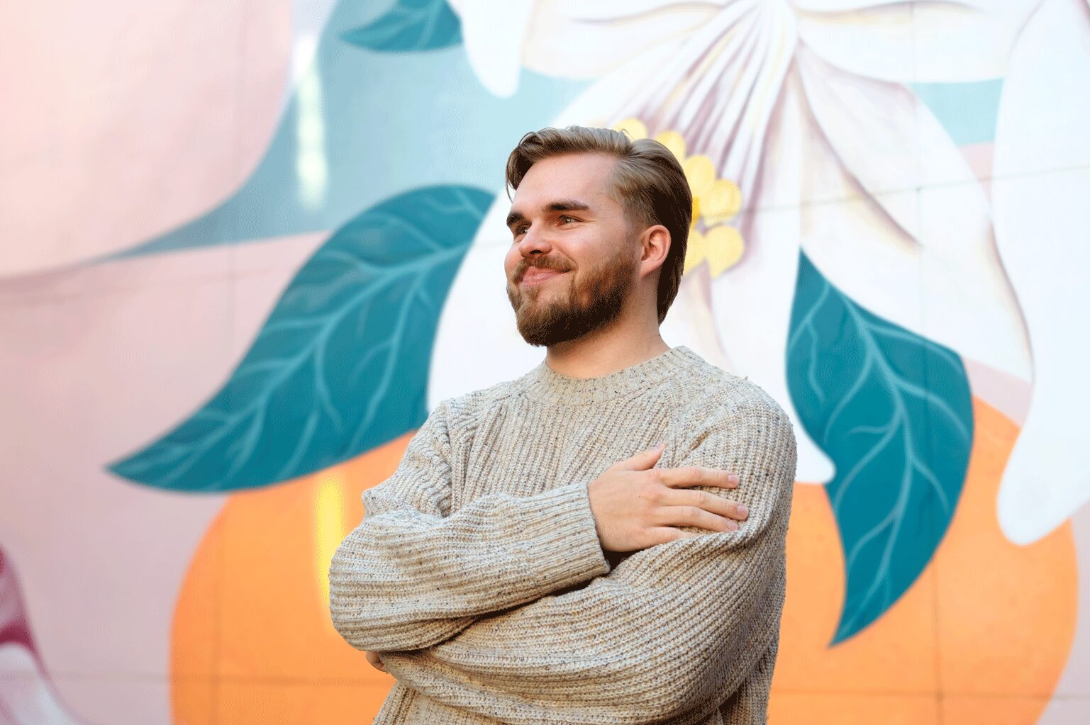 Harjoittelija Otto Puhakka kuvattuna muraalin edessä